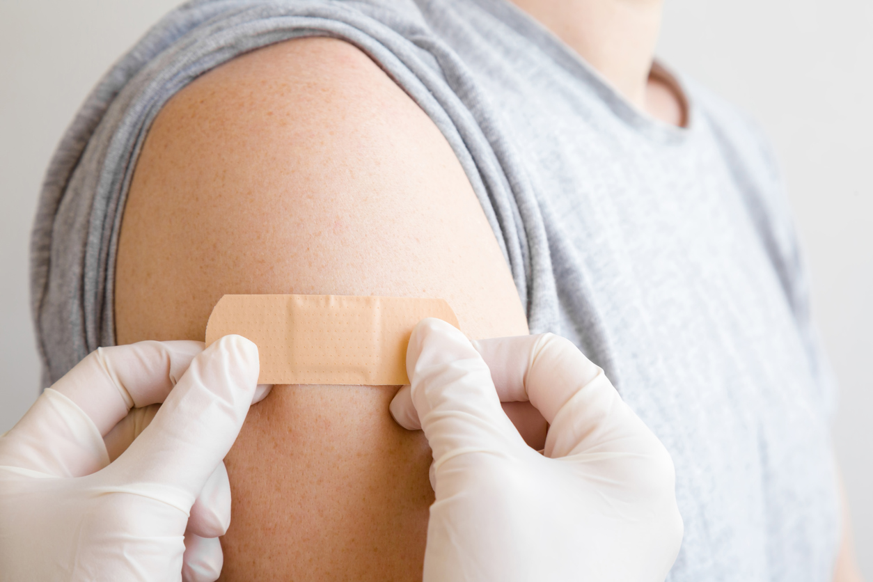 doctor applying a bandaid to a patient after a booster shot