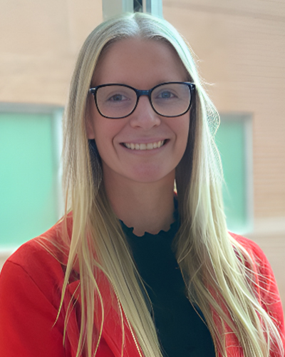 a woman wearing glasses and smiling at the camera