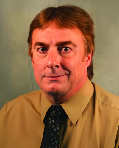 a man wearing a shirt and tie looking at the camera