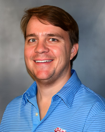 a smiling man in a blue shirt