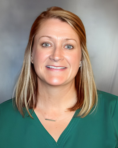 a woman in a green shirt smiling for a photo