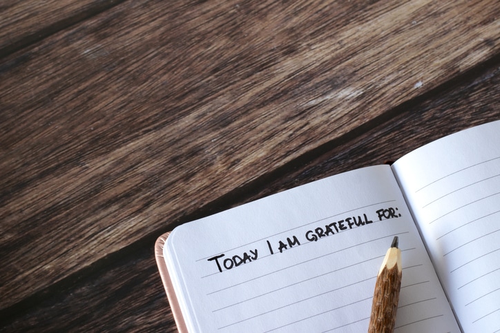 A Person Practices Gratitude By Keeping A Daily Journal And Starting Each Day With "Today, I Am Grateful For" Handwritten At The Top Of The Page With A Pencil In The Corner.