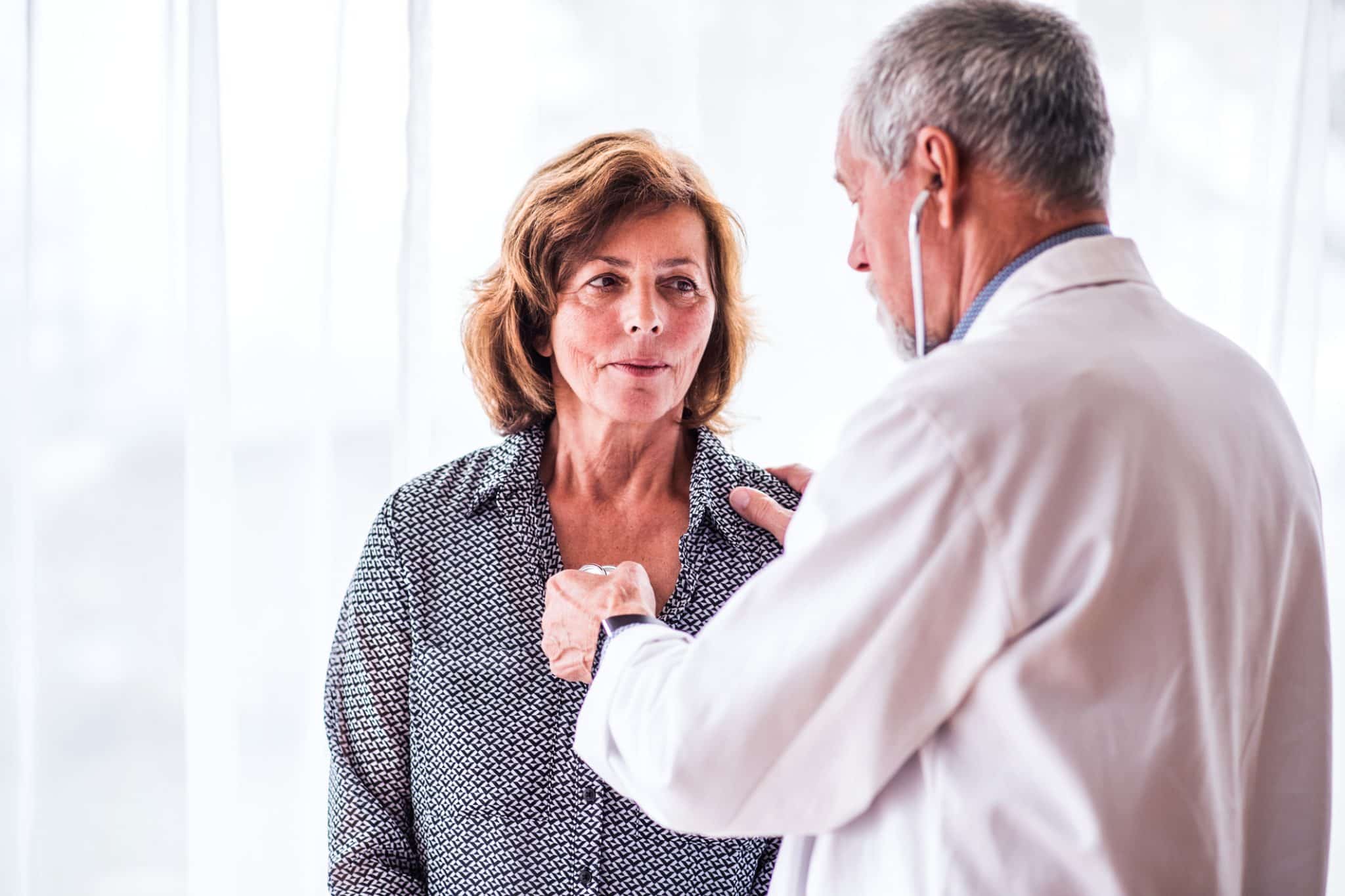 An internal medicine doctor examines a patient with a stethescope.