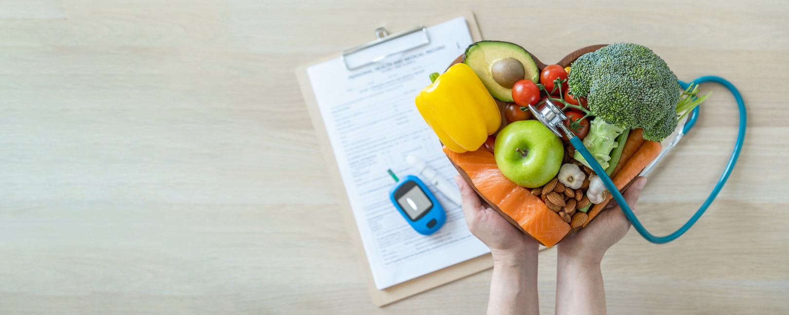 Fruits and vegetables arranged in a hear with a glucose monitor in the background.