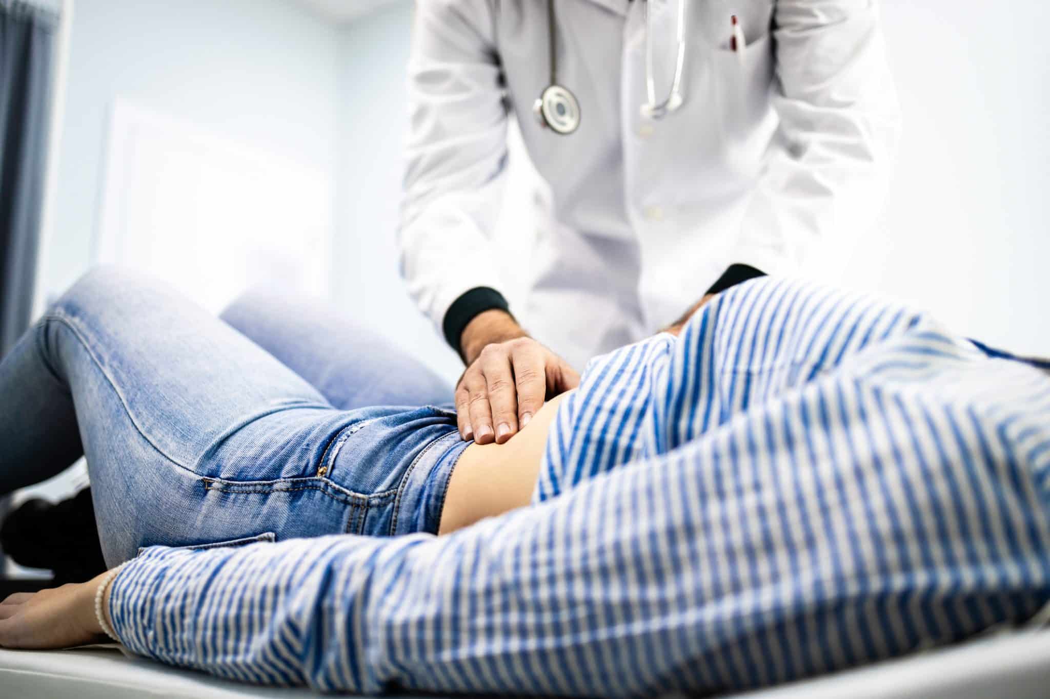 A gastroenterologist at UAB Medical West checking a patient's abdomen.