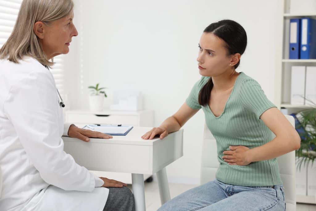 A patient at UAB Medical West describing her abdominal pain to a gastroenterologist in Alabama. 