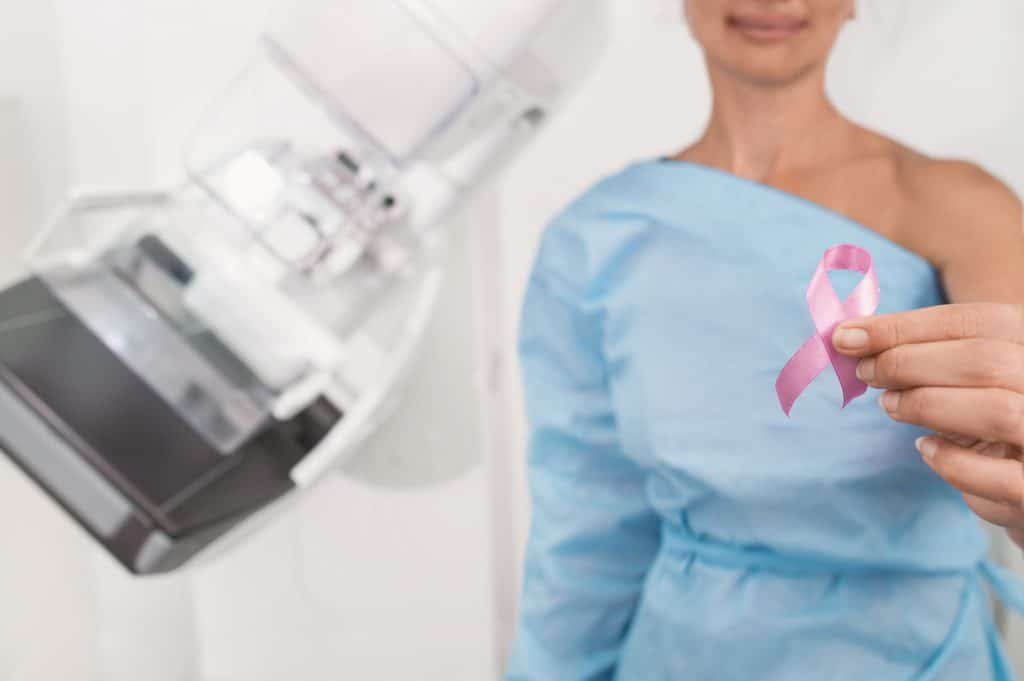 A woman holding a breast cancer awareness ribbon after getting a mammogram 