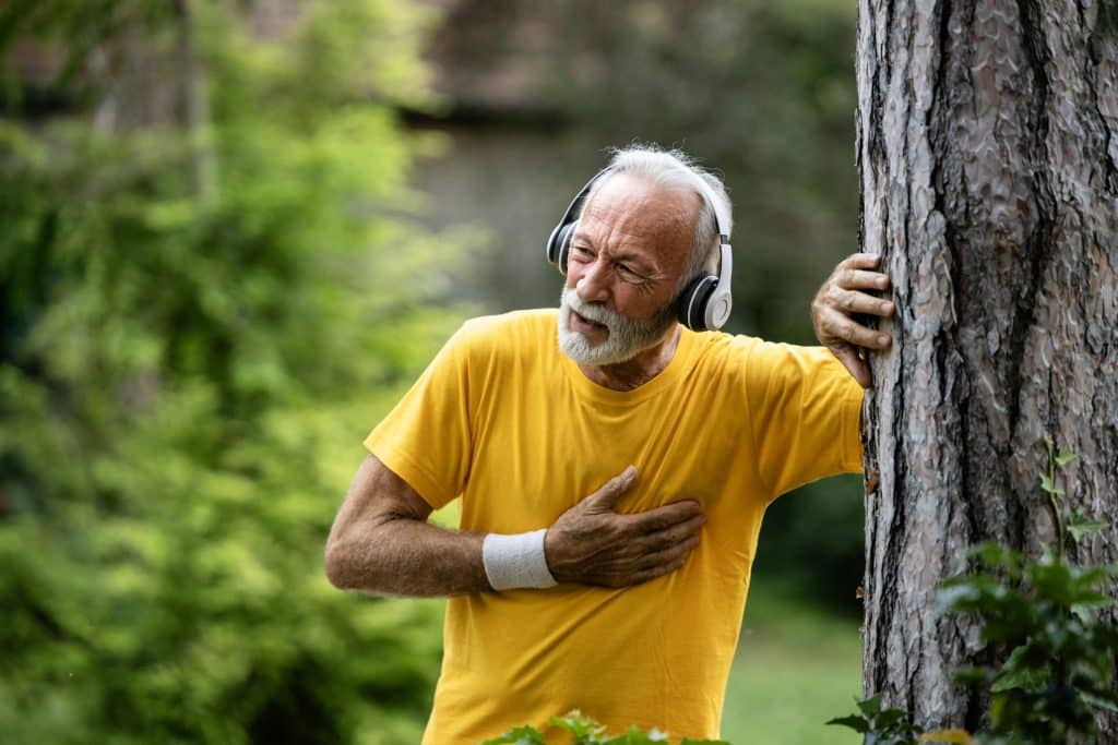 An older man experiencing shortness of breath while out for a brisk walk.