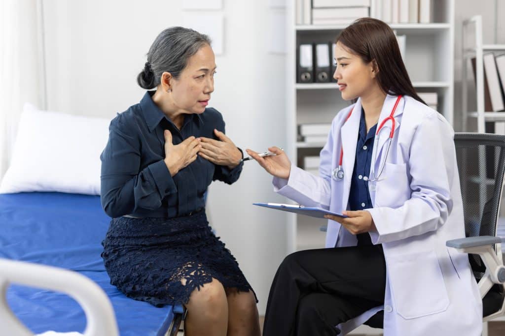 A woman describing her symptoms of shortness of breath to a pulmonologist.